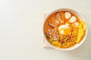 macarrão de ovo com carne de porco e almôndega na sopa picante foto