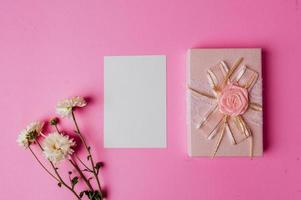 branco papel e presente caixa em Rosa fundo decorado com flores foto