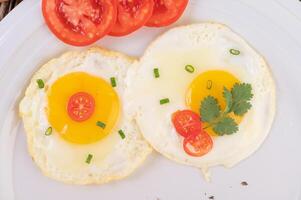 café da manhã Comida frito ovos com tomates em uma prato foto