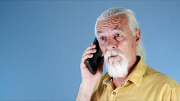 a branco cabelos velho homem fala em a celular foto