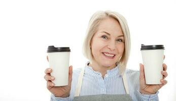 tempo parcial trabalho café pausa relaxar lazer pausa conceito. amigáveis agradável mulher barista dando dois grande café com leite isolado em cinzento fundo cópia-espaço foto