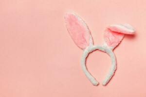 feliz Páscoa conceito. decorativo Coelho orelhas peludo traje brinquedo isolado em na moda pastel Rosa fundo foto