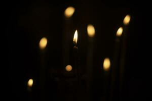 velas queimar dentro escuro. vela luzes. chamas em Preto fundo. foto