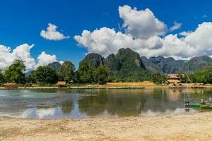 grandes rabo barcos em pôr do sol às música rio, vang vieng, Laos. foto