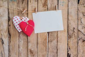 dois coração tecido e papel suspensão em varal de roupas às madeira fundo com espaço. foto