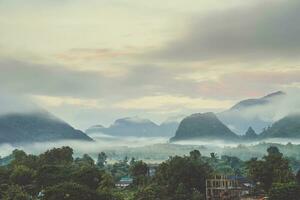 lindo nascer do sol e branco névoa com montanha às vang vieng, Laos. foto