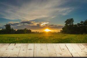 mesa de madeira e campo de arroz e céu azul do pôr do sol com reflexo de lente, montagem de exibição para o produto. foto
