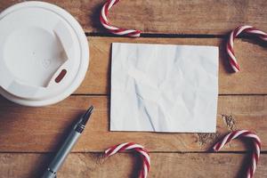 topo Visão café copo e caneta, em branco papel em madeira com Natal decoração para Novo ano conceito. foto