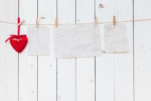 vermelho coração e velho papel em branco suspensão às varal de roupas em madeira branco fundo com espaço. namorados dia. foto