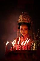 chinês mulher faço desejos, rezar, e luz velas. em a ocasião do a anual chinês Novo ano festival, dentro uma reverenciado santuário ou têmpora foto