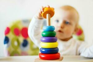 a criança tocam a pirâmide. criança jogando com de madeira brinquedos foto