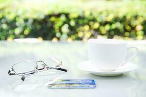 Óculos e café copo em mesa às casa foto