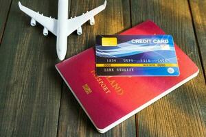 cartão de crédito colocado no passaporte na mesa de madeira foto