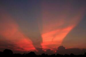 atmosfera dentro a tarde céu Como a Sol conjuntos - feixes - do a Sol e nuvens crio lindo cores e muitos cores, criando uma caloroso e romântico atmosfera em uma verão tarde. foto