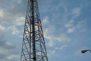 aço e cabo estrutura do alta Telefone postes contra lindo tarde azul céu fundo. foto