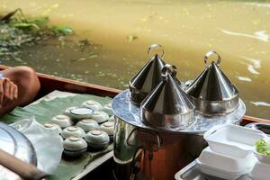 barcos vendendo vários tailandês sobremesas às maldição Saduak flutuando mercado é uma popular turista destino este europeus e chinês gostar para viagem dentro a tradicional caminho do vida do a aldeões. foto