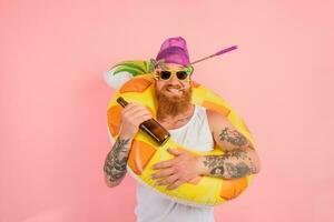 feliz homem é pronto para nadar com uma rosquinha salva-vidas com Cerveja e cigarro foto