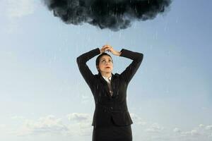 azarado empresária com uma Preto nuvem cheio do chuva sobre dela cabeça foto