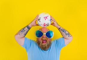 gordo homem com barba e oculos de sol ter Diversão com uma bola foto