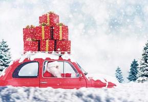 santa claus em uma vermelho carro cheio do Natal presente com inverno fundo drives para entregar foto