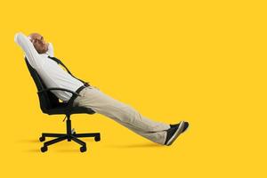 homem de negocios relaxar e pensar sentado em uma cadeira. amarelo fundo foto