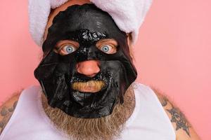 duvidoso homem com barba atos gostar uma mulher e tem Diversão com uma facial mascarar foto