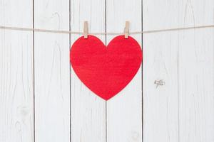 vermelho coração suspensão em branco madeira fundo com cópia de espaço. foto