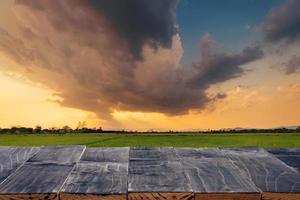 madeira mesa para produtos montagem e exibição com arroz campo pôr do sol. foto