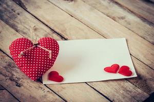 cumprimento cartão e vermelho corações com espaço para texto em de madeira fundo foto