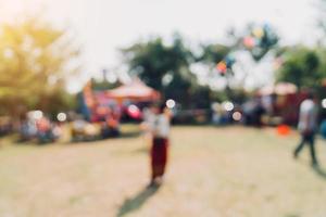 abstrato borrão pessoas e luz solar às festival dentro a cidade parque jardim com bokeh fundo. foto