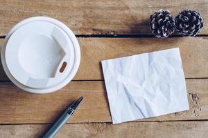 topo Visão café copo e caneta, em branco papel em madeira com Natal decoração para Novo ano conceito. foto