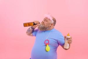 gordo homem atos gostar uma bebê mas bebidas Cerveja foto