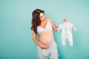 grávida mãe prepara a roupas para a bebê foto