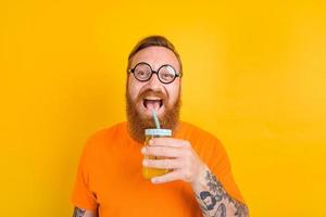 nerd feliz homem com óculos bebidas uma fruta suco foto