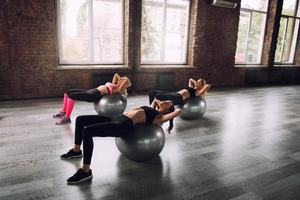 meninas trabalhando Fora às uma Academia com a gymball foto