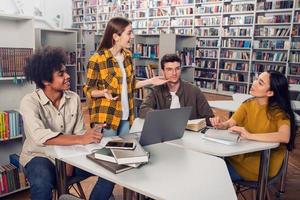 universidade alunos estão estudando dentro uma biblioteca junto. conceito do trabalho em equipe e preparação foto