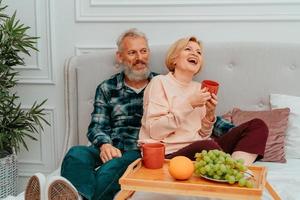 marido e esposa ter café da manhã em a cama com café e fruta foto