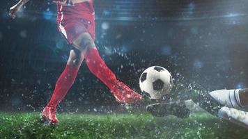 futebol cena às noite Combine com jogador dentro uma vermelho uniforme chutando a bola e oponente dentro enfrentar para defender foto