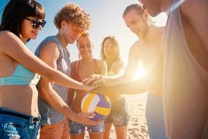 grupo do amigos este jogar vôlei de praia tendo Diversão em a de praia foto