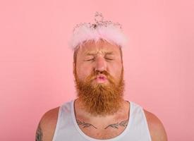 homem com barba , tatuagens e coroa atos gostar uma Princesa foto