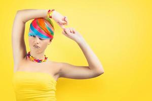 menina com arco Iris colorida moda Maquiagem em amarelo fundo. foto