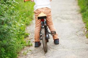 Garoto com uma bicicleta em a rua foto