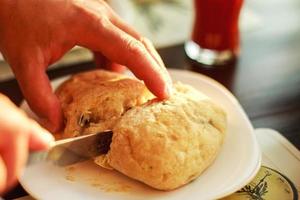 homem cortes fresco pão com uma faca foto