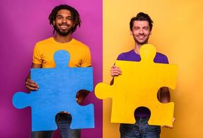 dois homens Junte-se peças do enigma Como conceito do trabalho em equipe, parceria e integração foto