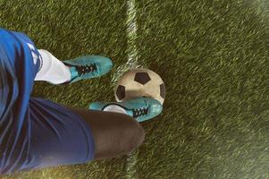 fechar acima do uma futebol atacante pronto para chutes a bola às a estádio foto