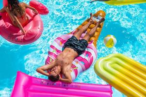 amigos dentro roupa de banho dentro a piscina obtendo uma bronzeado foto