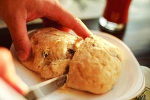 homem cortes fresco pão com uma faca foto