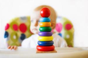 a criança tocam a pirâmide. criança jogando com de madeira brinquedos foto