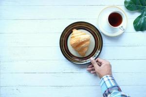 croissant e café na mesa foto
