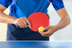 masculino jogando tênis de mesa com raquete e bola em um ginásio esportivo foto